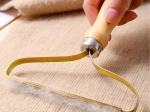 Levapelucchi manuale per abbigliamento e tappezzeria con manico in legno